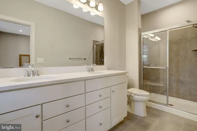 a bathroom with a double vanity sink toilet and shower