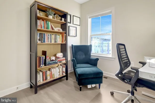 a living room with furniture a bookshelf and a window