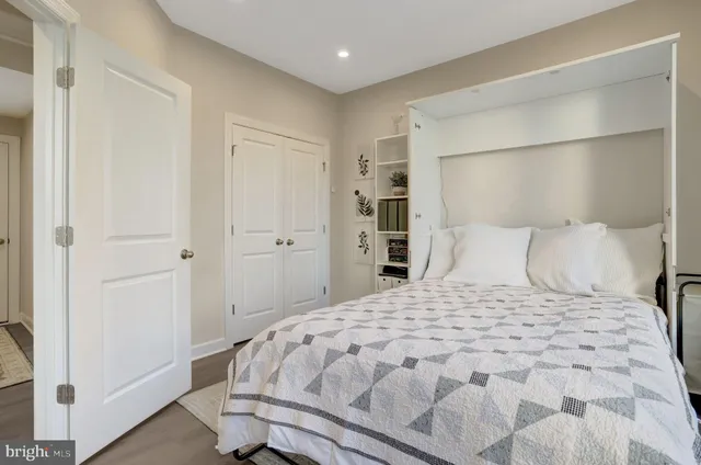 a bedroom with a large bed and a flat tv screen on dresser