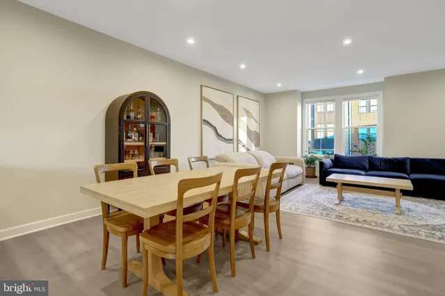 a view of a dining room and livingroom with furniture a rug and a painting