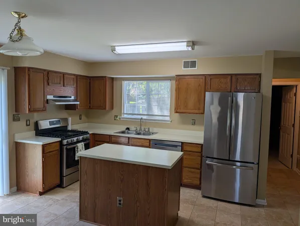 a kitchen with kitchen island a sink stove and refrigerator