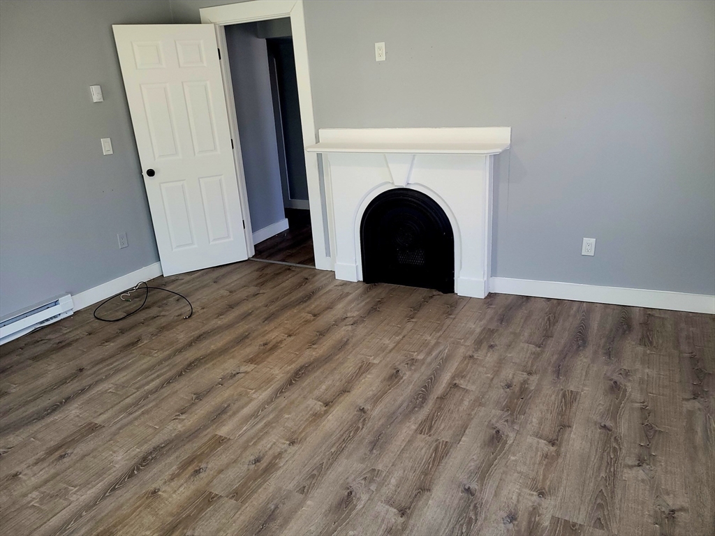 136 Commonwealth Road Wayland, MA 01778 - Photo 8 of 27 a view of empty room with fireplace and wooden floor
