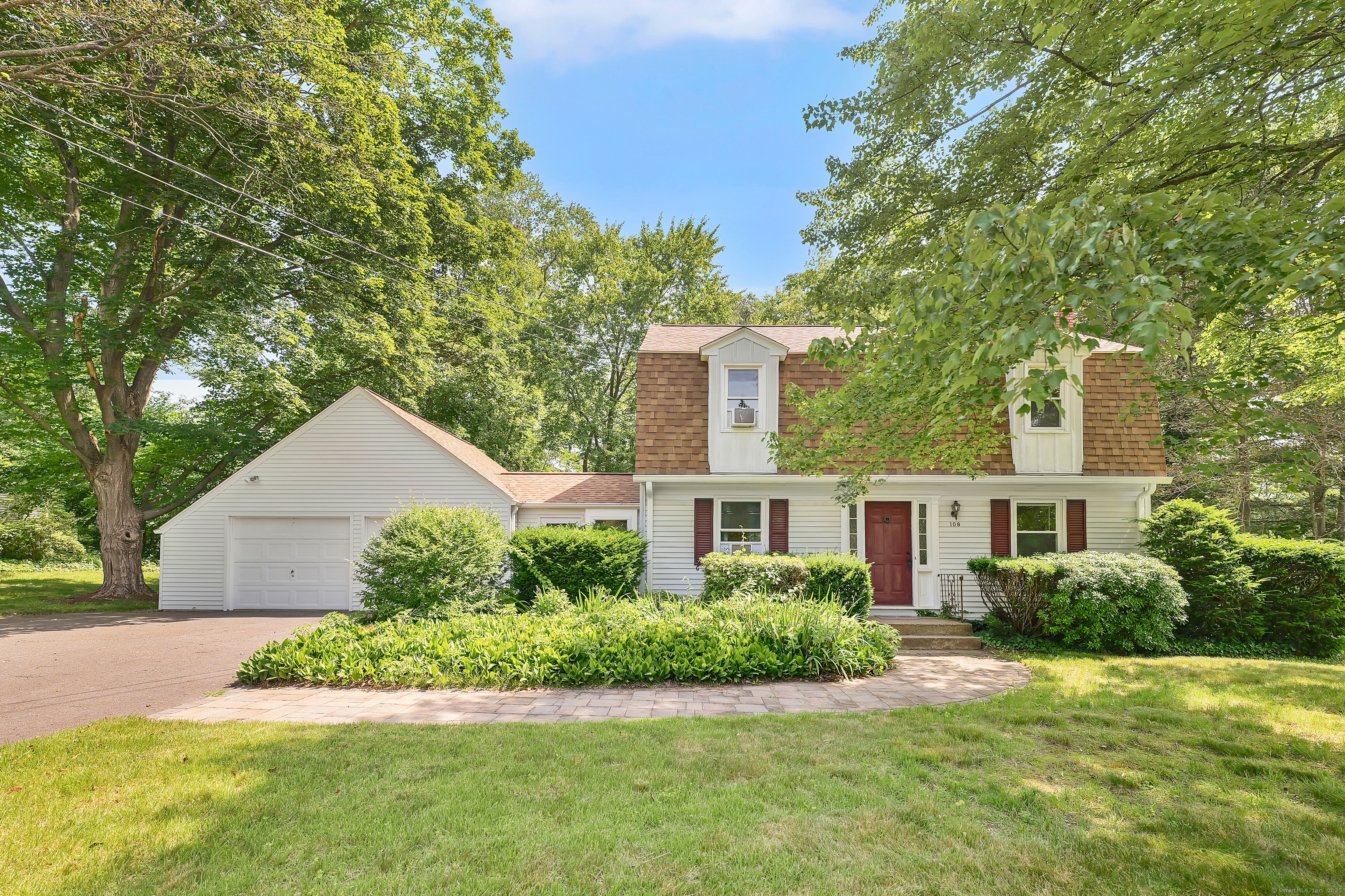 a front view of a house with a yard and potted plants