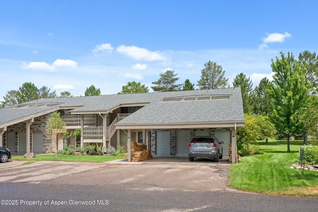 a front view of a house with a garden and trees