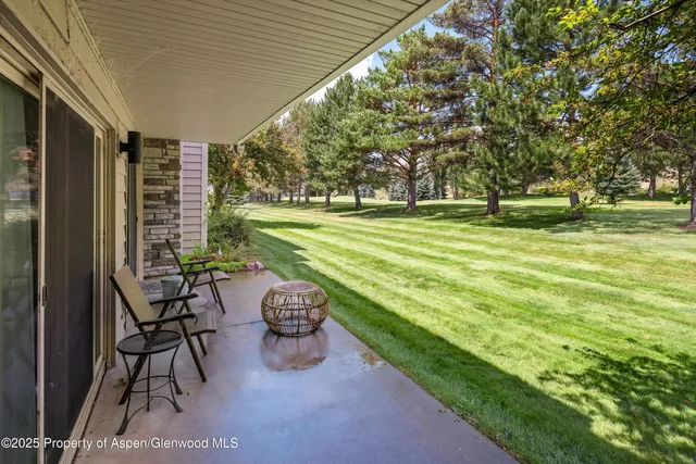 a view of a chair and table on the deck in front of house