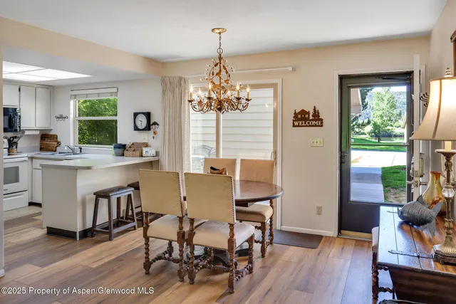 a dining room with furniture a chandelier and wooden floor
