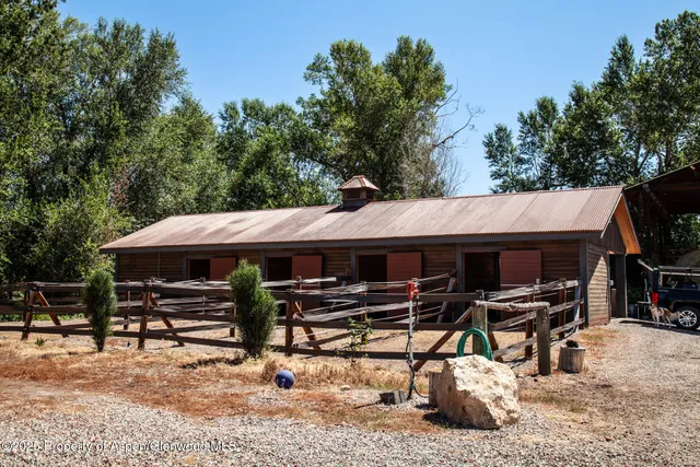 a view of a patio with table and chairs a barbeque with wooden fence and floor