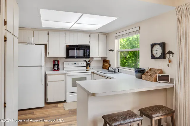 a kitchen with a refrigerator a stove a sink a window and a cabinets