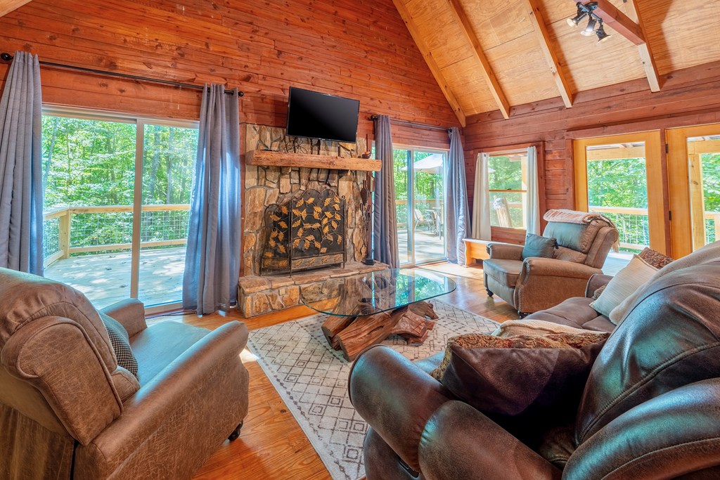 84 Knights Way Blairsville, GA 30512 - Photo 12 of 51 a living room with furniture a flat screen tv and floor to ceiling windows