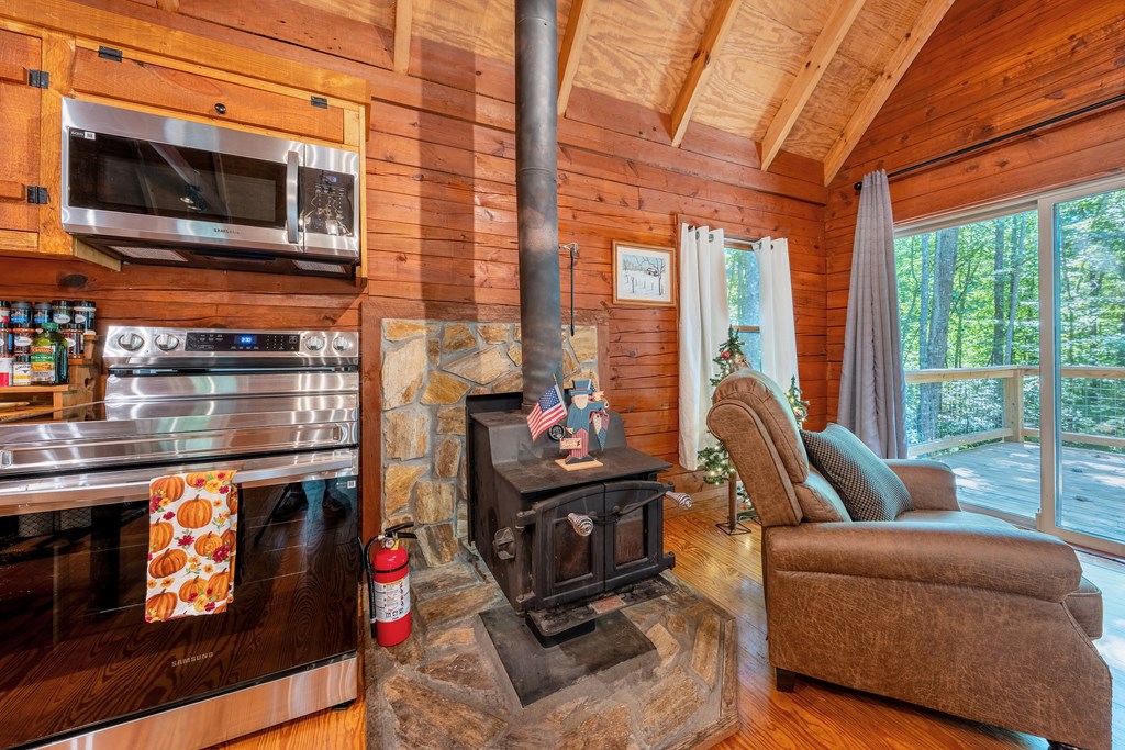 84 Knights Way Blairsville, GA 30512 - Photo 34 of 51 a living room with furniture a flat screen tv and a floor to ceiling window