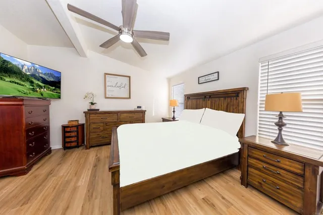 a bed room with a bed and a ceiling fan