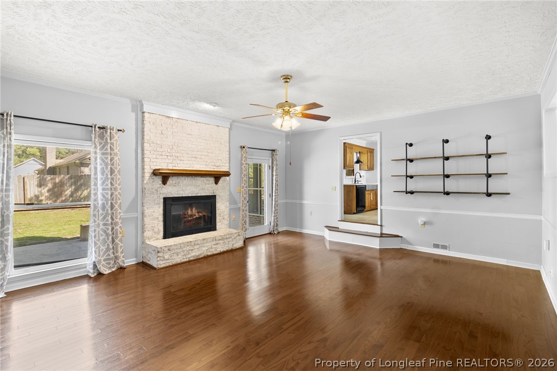 7756 Dragonhead Road Fayetteville, NC 28311 - Photo 32 of 42 a view of a livingroom with wooden floor a fireplace and window