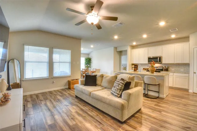 a kitchen with stainless steel appliances granite countertop a stove a sink dishwasher and a refrigerator with wooden floor