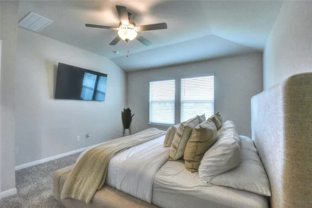 a bedroom with a large bed and a chandelier