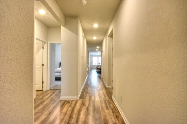 a view of a hallway with wooden floor
