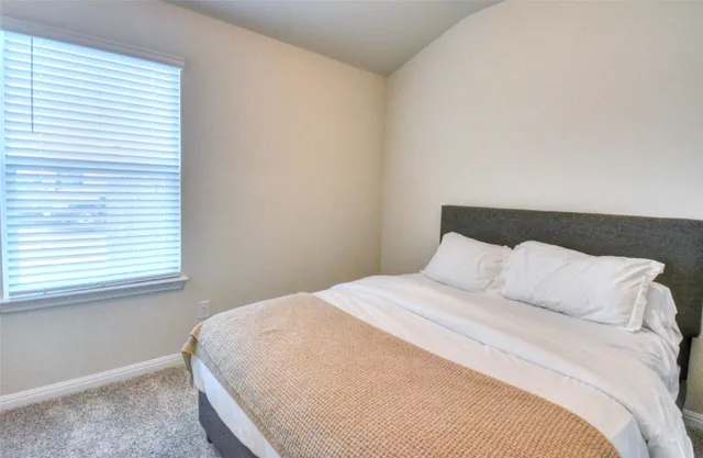 a large bed sitting in a bedroom next to a window