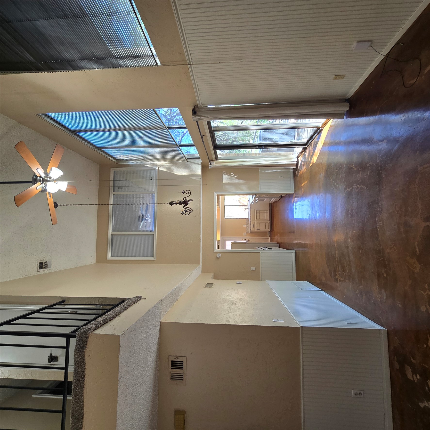 801 Ranch Road 12 San Marcos, TX 78666 - Photo 19 of 21 Unfurnished living room with a wainscoted wall, a high ceiling, a ceiling fan, and finished concrete floors