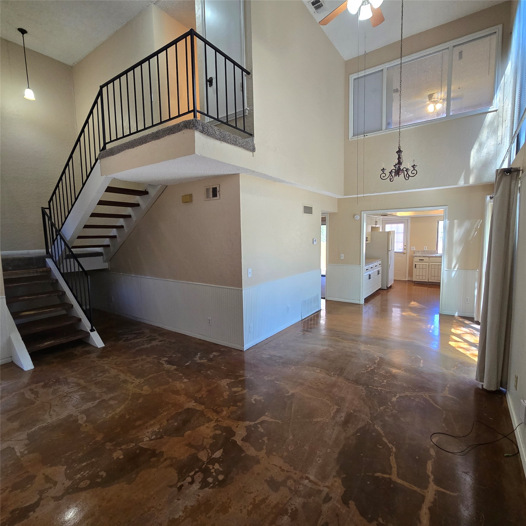 801 Ranch Road 12 San Marcos, TX 78666 - Photo 3 of 21 Unfurnished living room featuring wainscoting, a ceiling fan, and a high ceiling