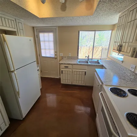 a kitchen with sink a refrigerator and a stove