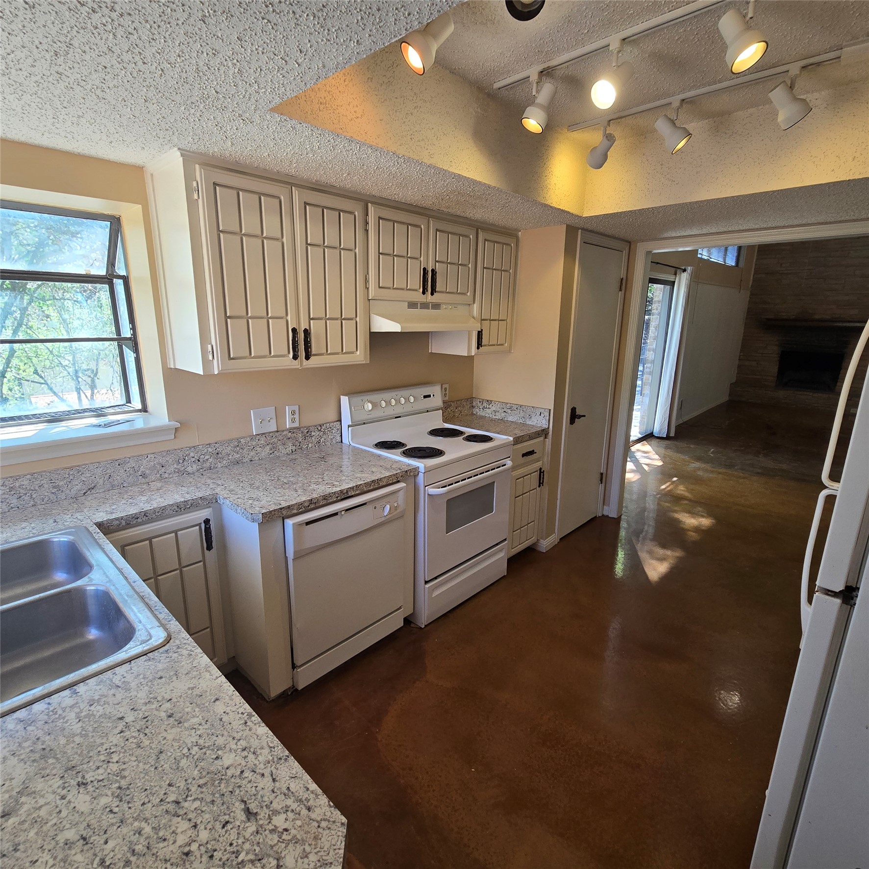 801 Ranch Road 12 San Marcos, TX 78666 - Photo 8 of 21 Kitchen featuring plenty of natural light, light countertops, white appliances, finished concrete flooring, and a textured ceiling