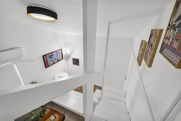 a living room with stainless steel appliances kitchen island granite countertop a stove a sink dishwasher and a microwave oven with wooden floor