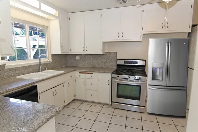 a kitchen with cabinets stainless steel appliances and a sink