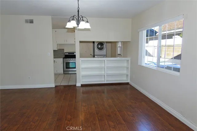a view of a livingroom with wooden floor a ceiling fan and window