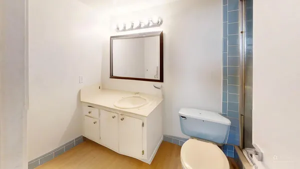 a bathroom with a toilet sink and mirror
