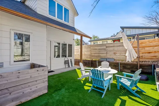 a view of a chair and table in backyard of the house