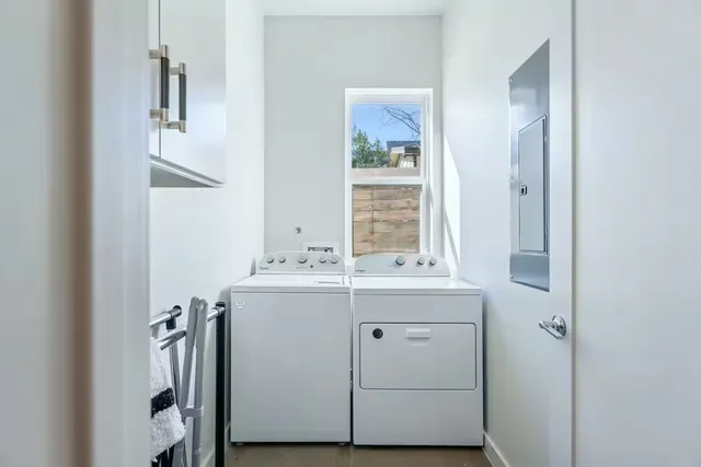 a utility room with cabinets washer and dryer