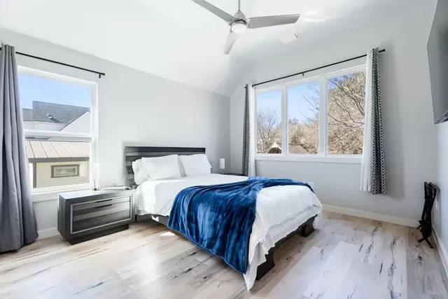 a bedroom with a bed and a large window