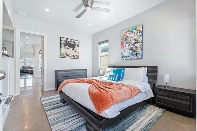 a bedroom with bed and paintings on the wall