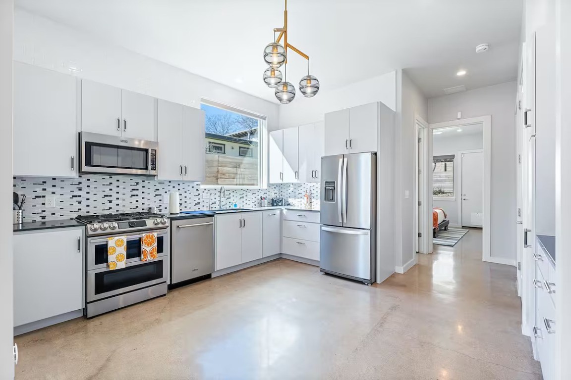 4314 Jinx Avenue, Unit A Austin, TX 78745 - Photo 6 of 40 a kitchen with stainless steel appliances granite countertop a refrigerator a stove a oven a sink dishwasher and a refrigerator with wooden floor