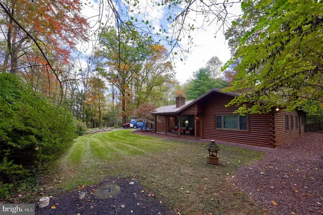 a backyard of a house with trees and outdoor seating