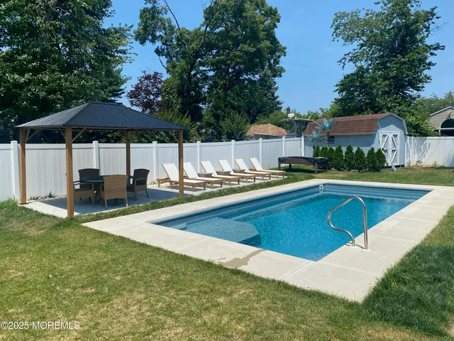 a view of a house with swimming pool and sitting area