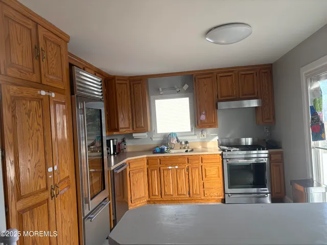 a kitchen with stainless steel appliances granite countertop a sink stove and refrigerator