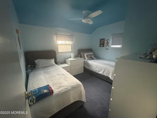 a bedroom with two bed and a chandelier