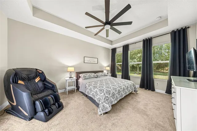 a bedroom with a bed a couch and a large window