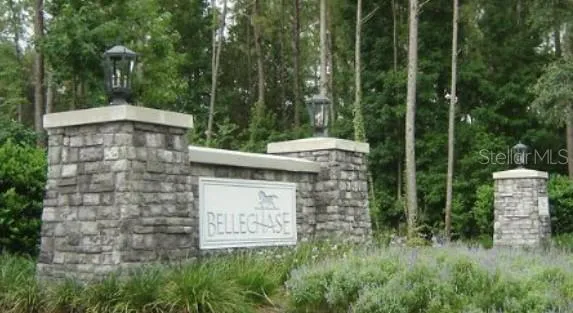 a view of a wooden house with a small yard and large trees
