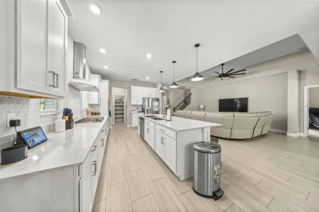 a large white kitchen with a large window and stainless steel appliances