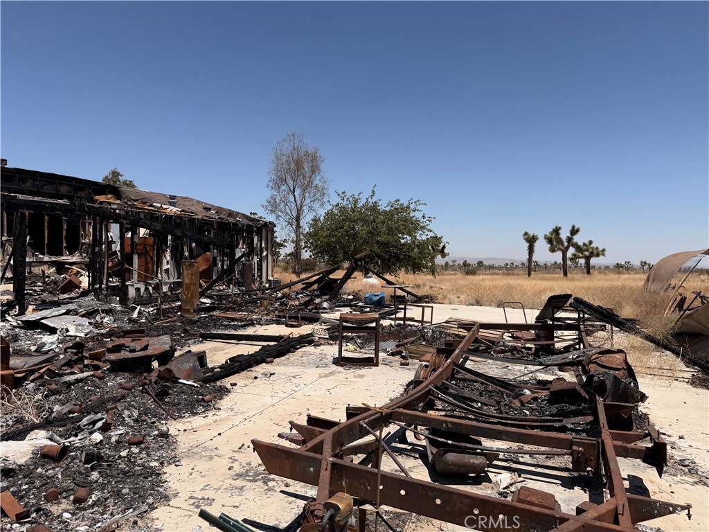 12225 Lager Road Phelan, CA 92371 - Photo 11 of 18 Charred vehicle chassis and backyard debris