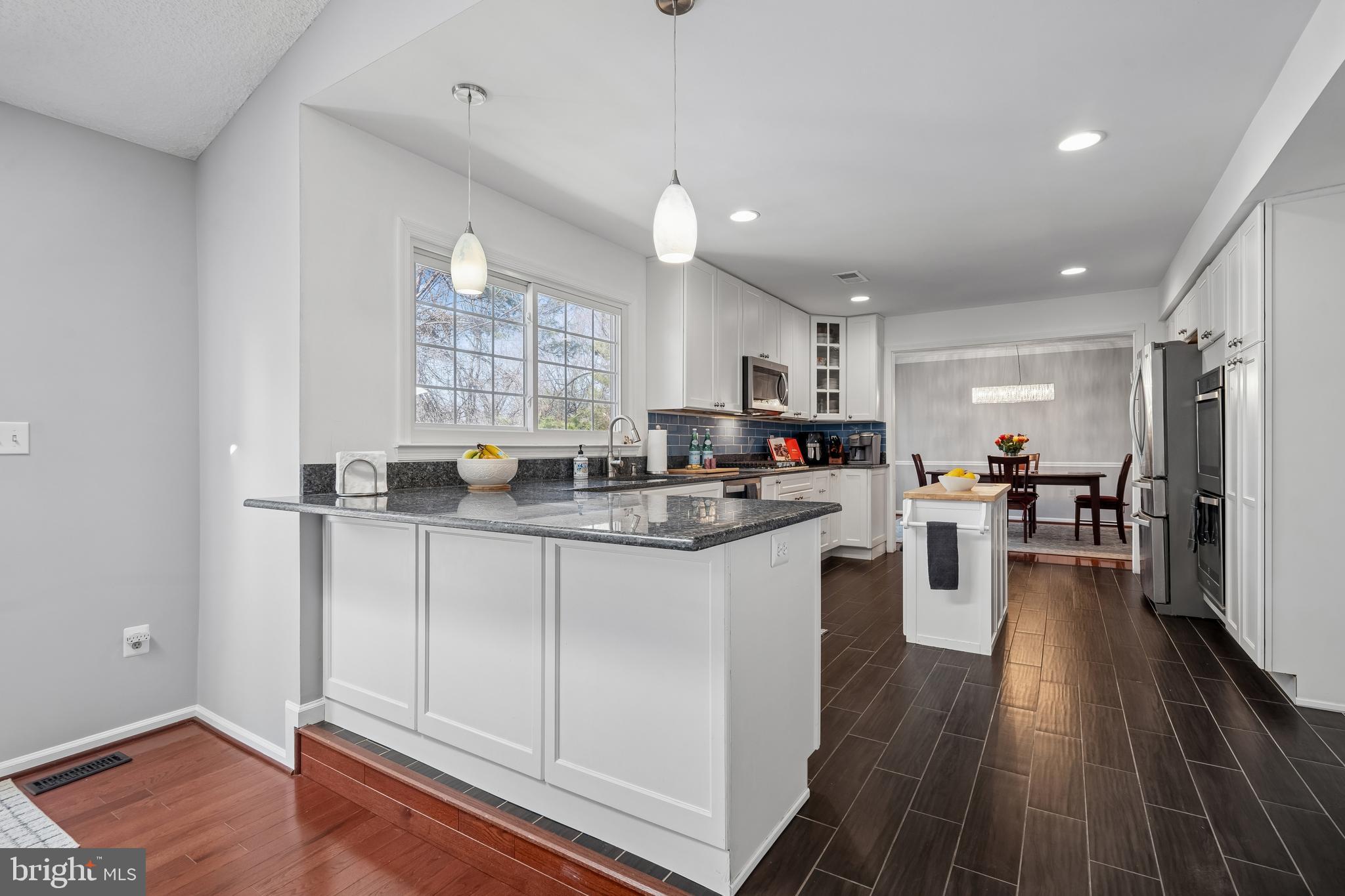 13525 Winding Trail Court Silver Spring, MD 20906 - Photo 12 of 40 a kitchen with stainless steel appliances granite countertop a refrigerator a sink dishwasher a stove and white cabinets with wooden floor