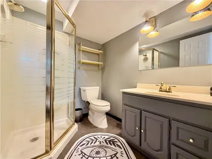 a bathroom with a granite countertop toilet sink and a mirror