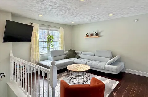 a living room with furniture a flat screen tv and a window