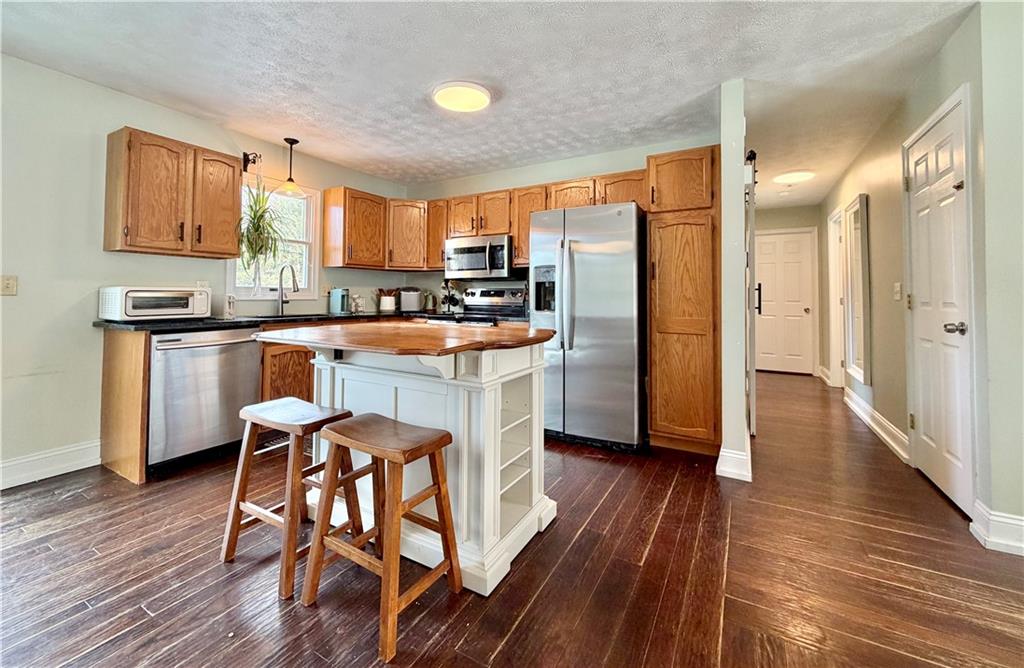 110 West McQuistion Road Butler, PA 16001 - Photo 5 of 32 a kitchen with granite countertop wooden floors and white stainless steel appliances