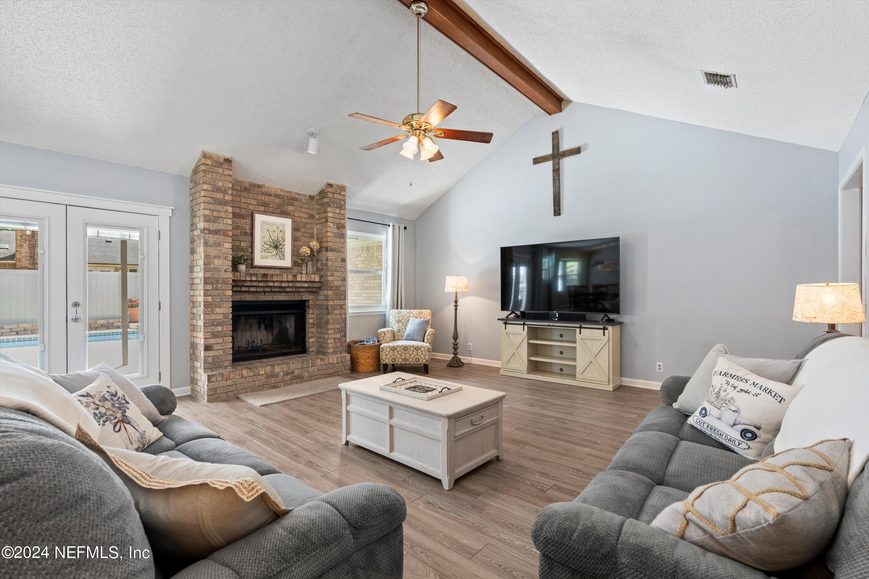 1474 Fruit Cove Forest Road North St. Johns, FL 32259 - Photo 13 of 36 a living room with furniture a flat screen tv and a fireplace
