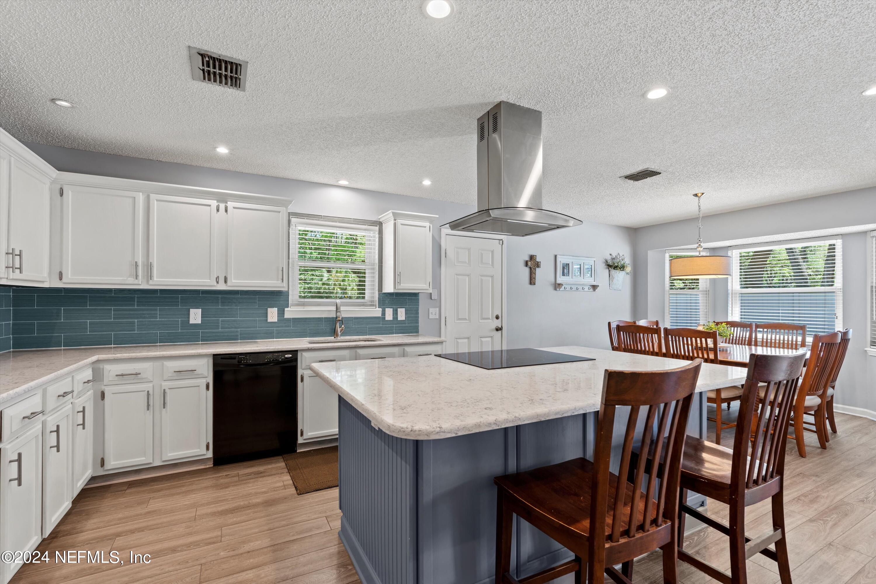 1474 Fruit Cove Forest Road North St. Johns, FL 32259 - Photo 15 of 36 a kitchen with stainless steel appliances granite countertop a table chairs sink and stove top oven
