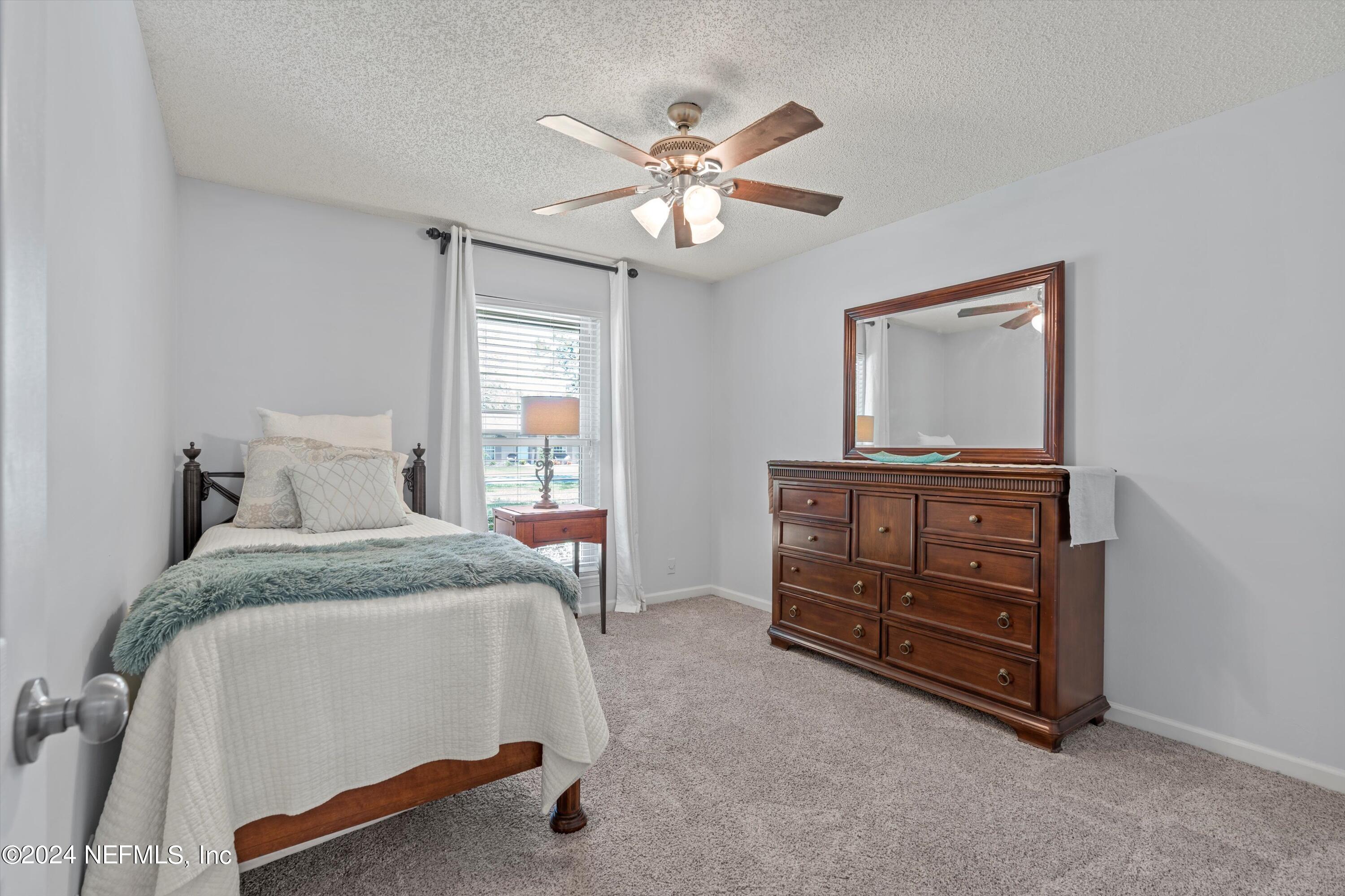 1474 Fruit Cove Forest Road North St. Johns, FL 32259 - Photo 23 of 36 a spacious bedroom with a bed and a dresser