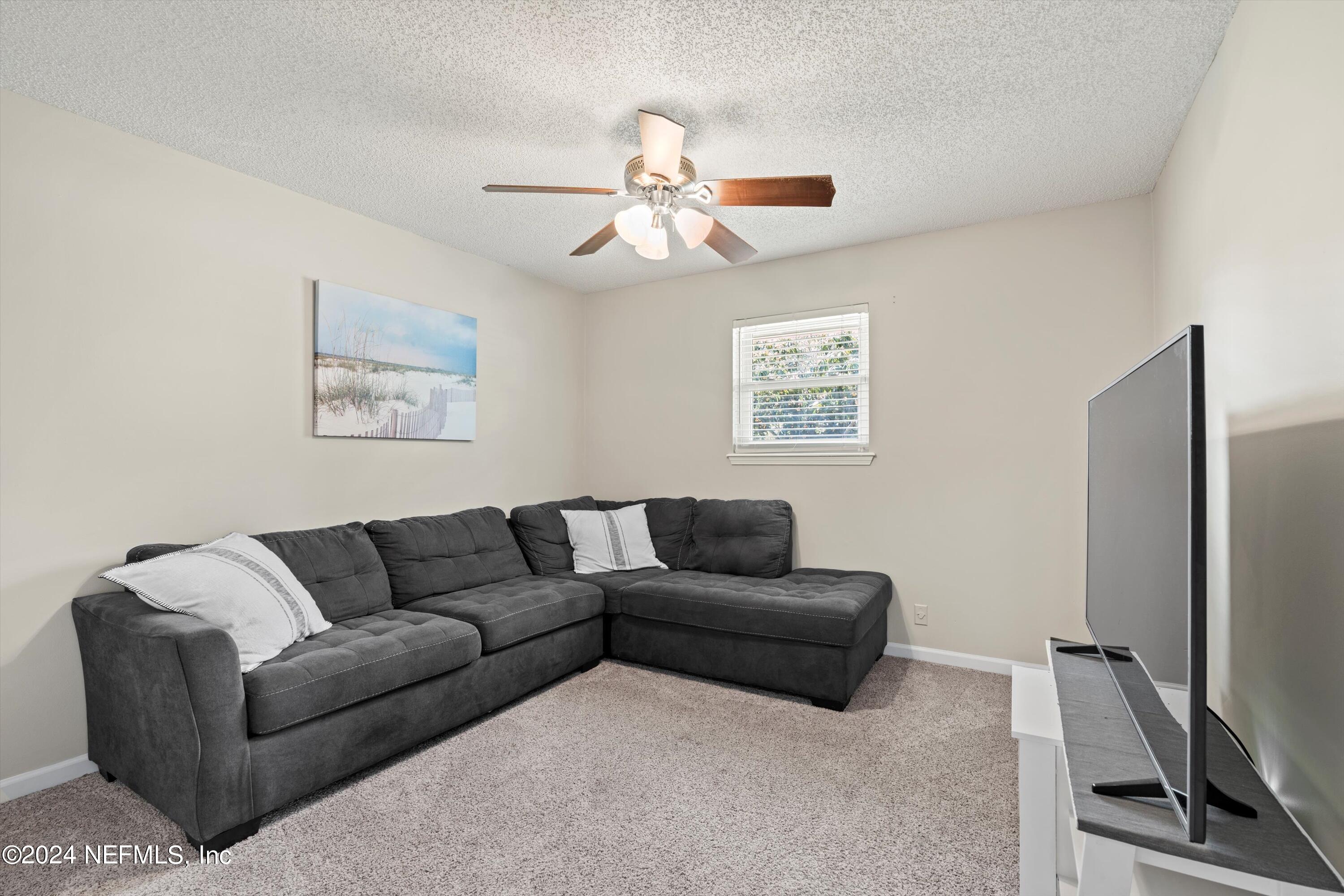 1474 Fruit Cove Forest Road North St. Johns, FL 32259 - Photo 26 of 36 a living room with furniture a ceiling fan and a window