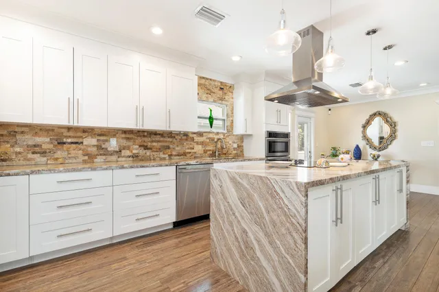 a kitchen with granite countertop white cabinets and white appliances
